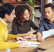 young couple looking over papers with financial advisor